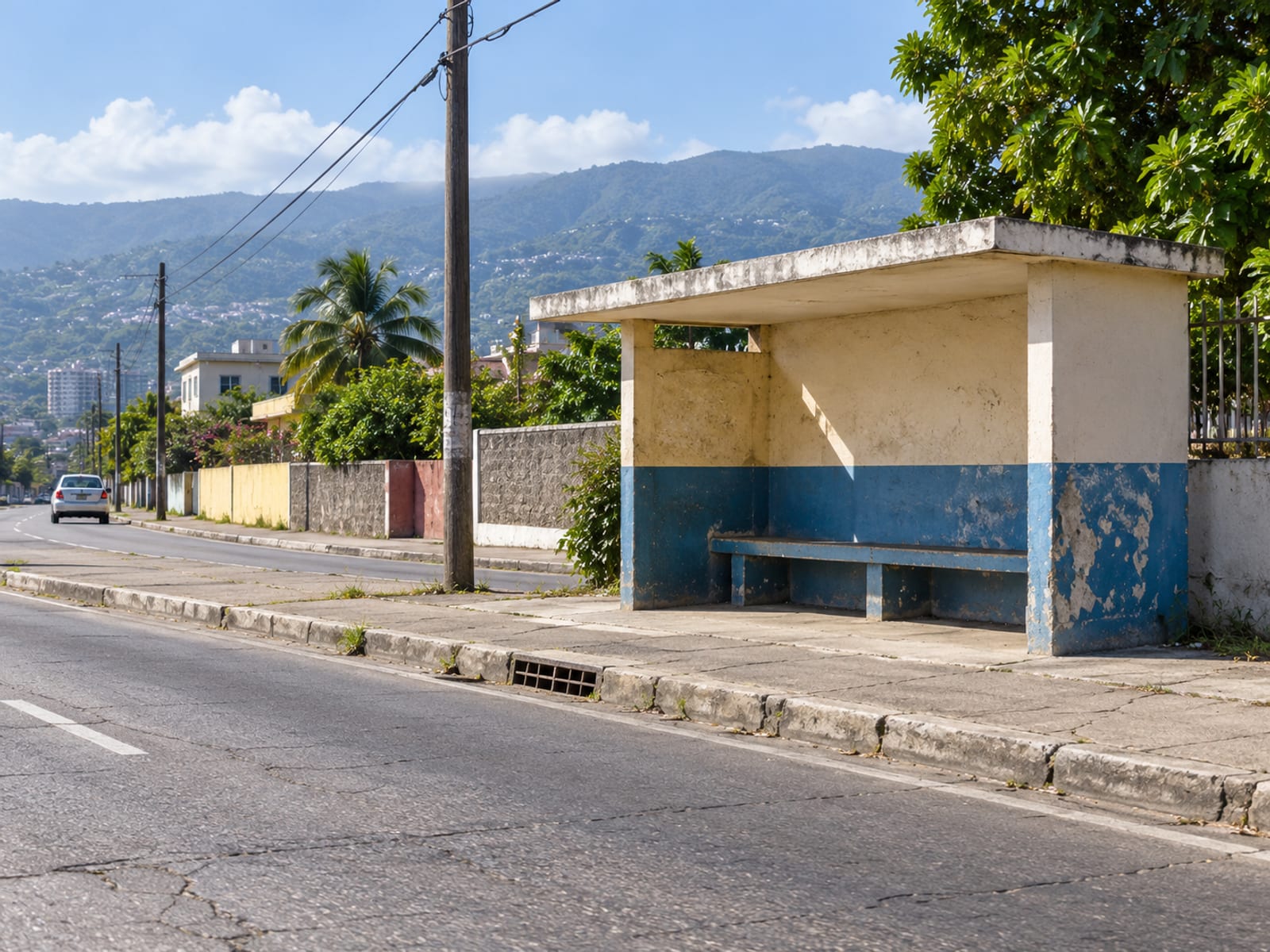 Empty roadside bench and shelter on a town street in bright daytime with hills behind