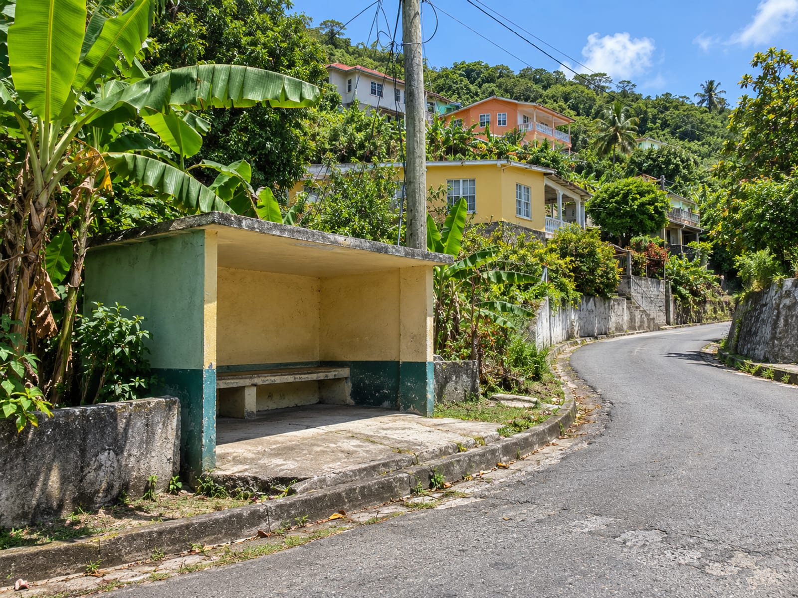 Plain empty shelter beside a narrow road at a bend in a hill village with houses and trees