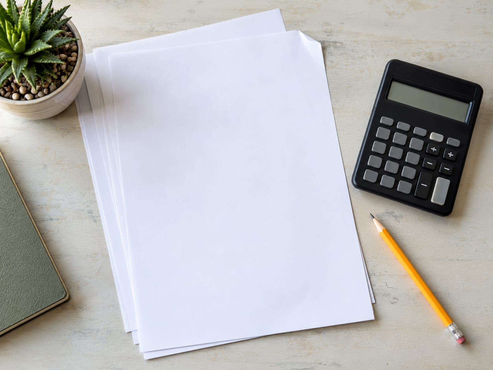 Top down view of blank sheets, a plain calculator and a pencil on a pale desk