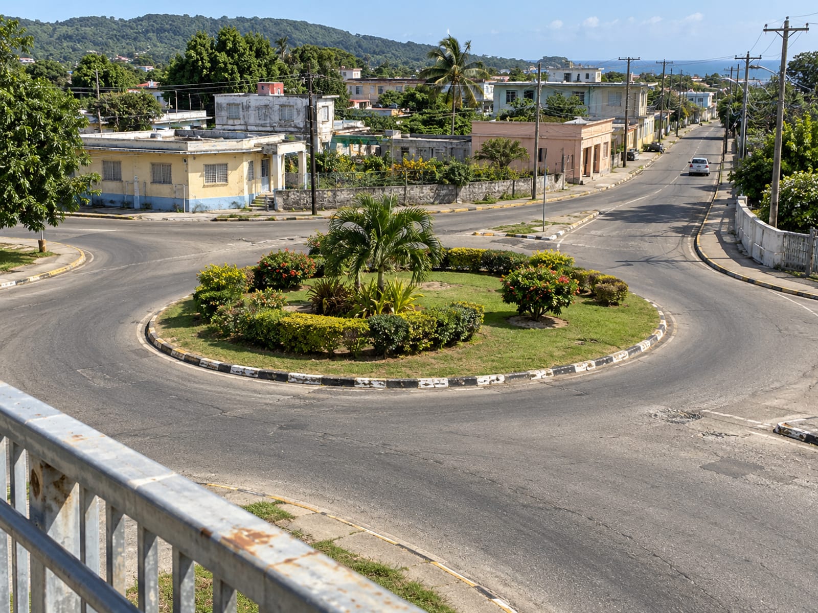 Small roundabout with a planted centre on a quiet town street seen from a footbridge