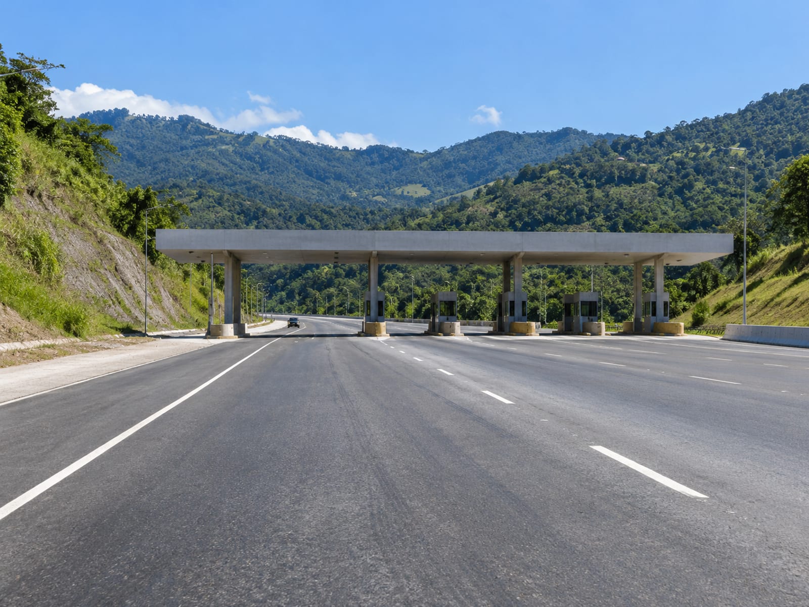 Distant toll plaza canopy over several lanes on a wide highway under open sky