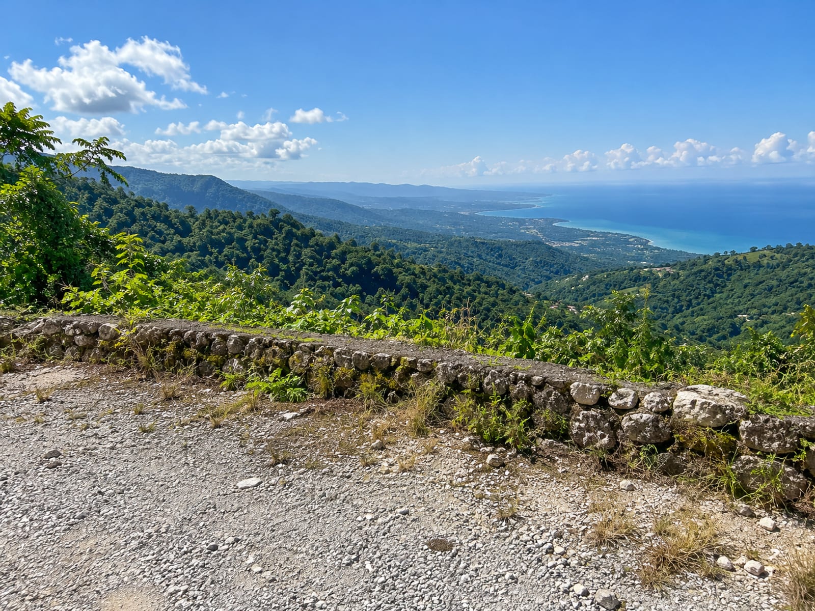 Empty roadside lay by overlooking green hills and the sea with no vehicle in sight